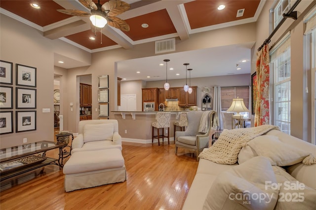 living room with coffered ceiling, light wood-type flooring, beam ceiling, and visible vents