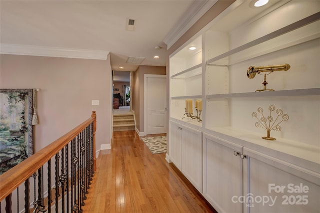 corridor featuring ornamental molding, recessed lighting, baseboards, and light wood finished floors