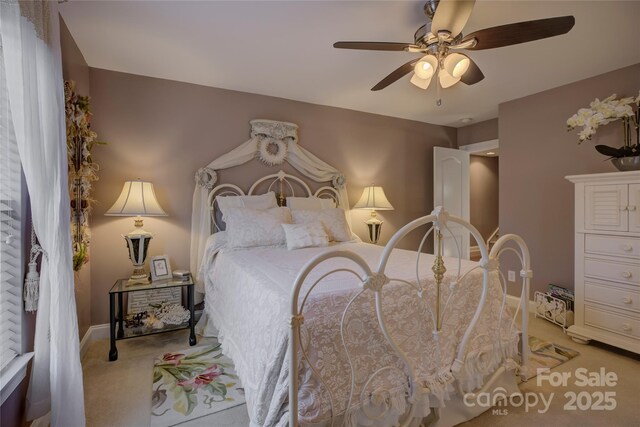 bedroom with baseboards, a ceiling fan, and light colored carpet