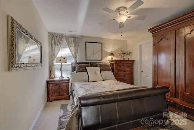 bedroom with baseboards, a ceiling fan, visible vents, and light colored carpet