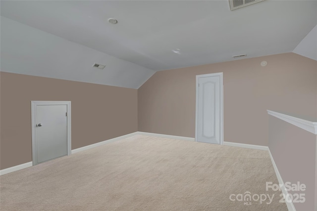 additional living space featuring vaulted ceiling, carpet, and visible vents