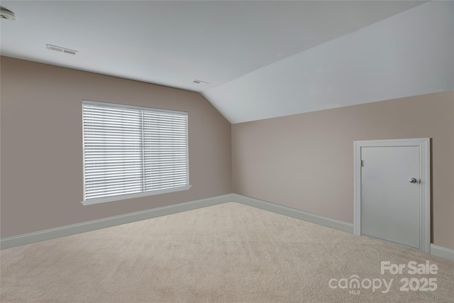 bonus room featuring lofted ceiling, carpet floors, visible vents, and baseboards