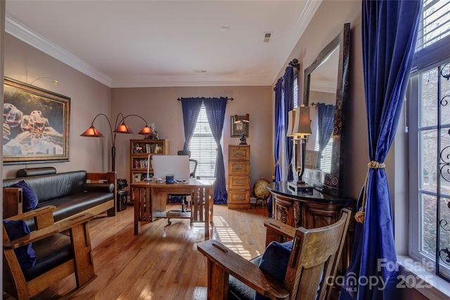 home office with ornamental molding, visible vents, and light wood-style floors