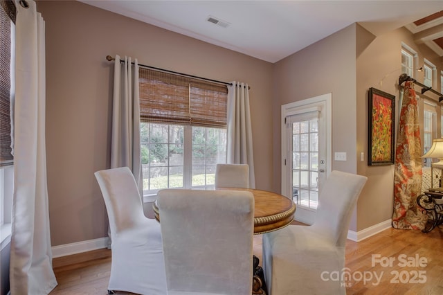 dining area with baseboards, visible vents, and light wood-style floors