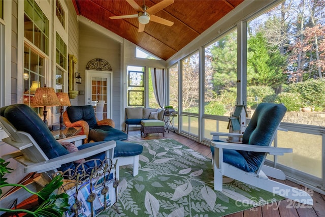 sunroom featuring lofted ceiling, wooden ceiling, and a ceiling fan