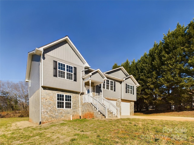 view of front of property with a front lawn, covered porch, and a garage