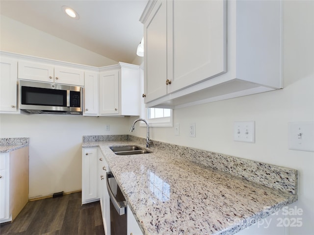 kitchen featuring light stone countertops, appliances with stainless steel finishes, and white cabinetry