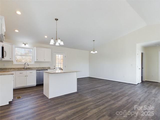 kitchen featuring stainless steel dishwasher, decorative light fixtures, a center island, and white cabinetry