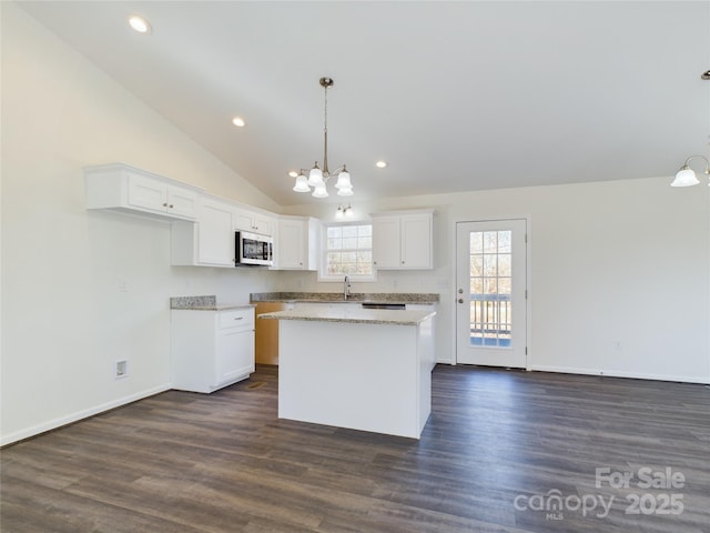 kitchen with sink, hanging light fixtures, dark hardwood / wood-style floors, a kitchen island, and white cabinetry