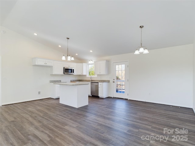 kitchen with white cabinets, a kitchen island, stainless steel appliances, and pendant lighting