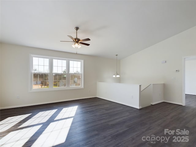 unfurnished room with lofted ceiling, dark wood-type flooring, and ceiling fan with notable chandelier