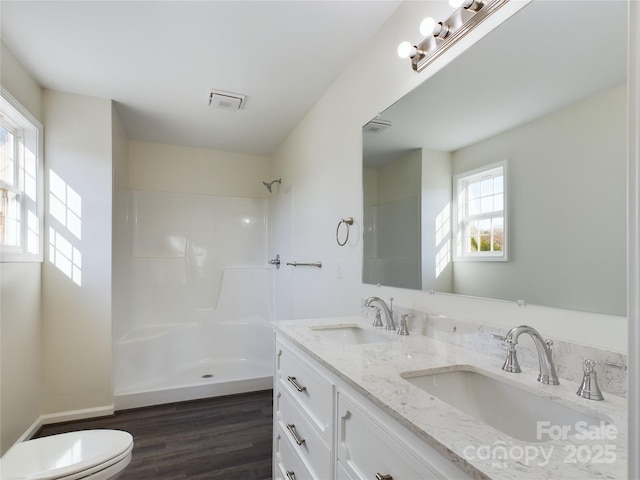 bathroom with a shower, wood-type flooring, vanity, and toilet