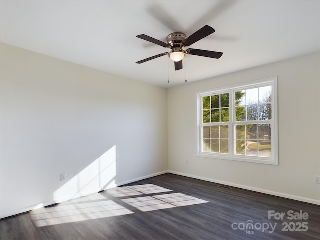 empty room featuring dark hardwood / wood-style flooring and ceiling fan