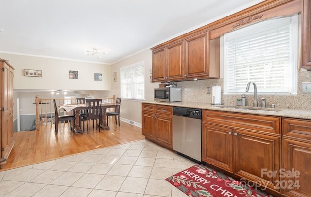 kitchen with backsplash, crown molding, sink, appliances with stainless steel finishes, and light hardwood / wood-style floors