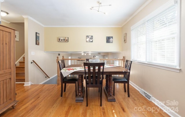 dining area featuring crown molding and light wood-type flooring