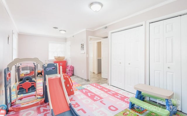 bedroom with crown molding and two closets