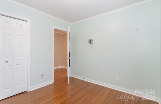 unfurnished bedroom with ornamental molding and hardwood / wood-style flooring