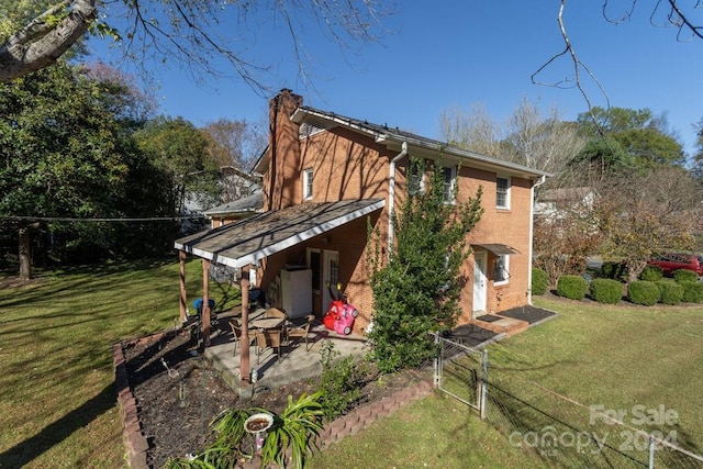 rear view of property with a patio and a lawn