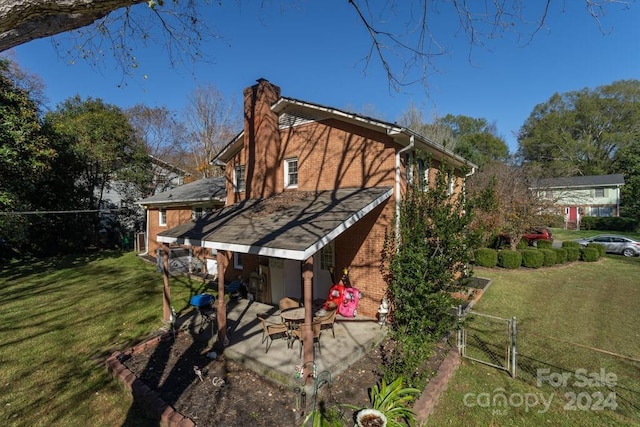 rear view of property featuring a patio area and a yard