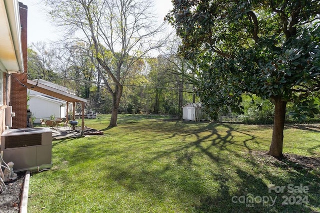 view of yard featuring a storage unit and central AC