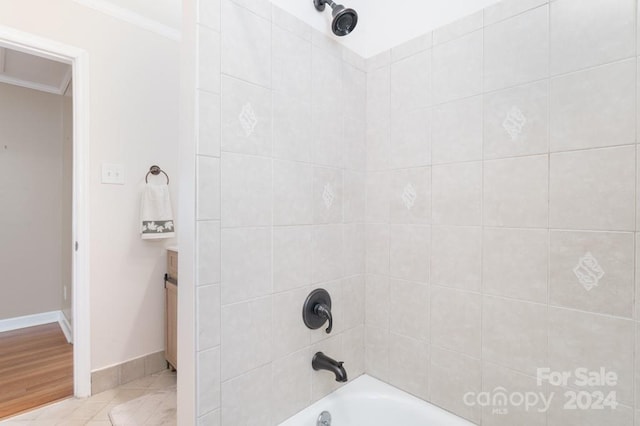 bathroom with vanity, tiled shower / bath combo, hardwood / wood-style flooring, and ornamental molding