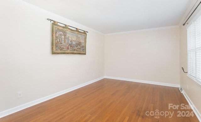 unfurnished room featuring hardwood / wood-style floors and crown molding