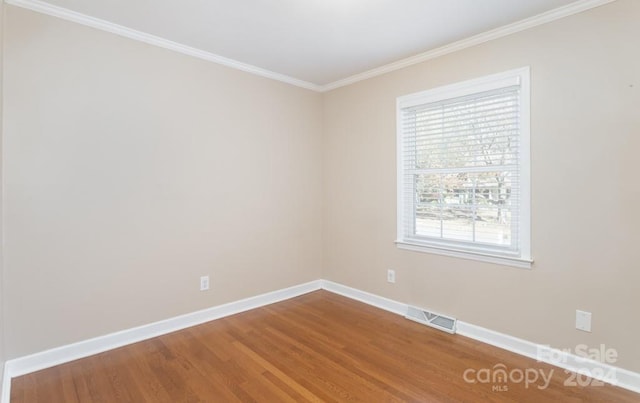 unfurnished room with wood-type flooring and crown molding