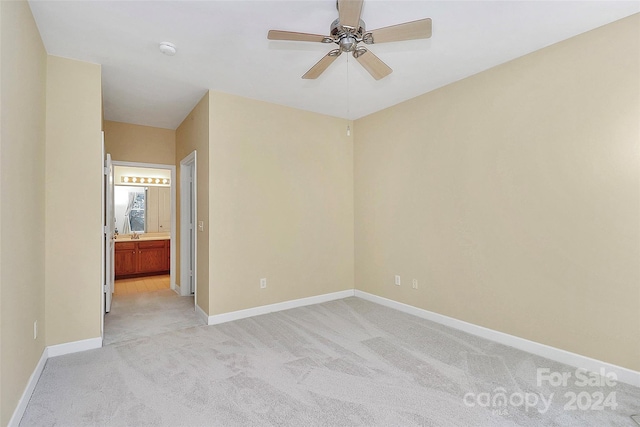 spare room featuring ceiling fan and light carpet