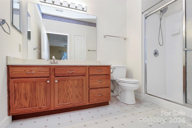 bathroom featuring vanity, toilet, and a shower with shower door