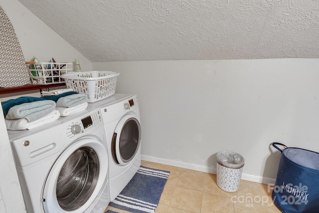 washroom with separate washer and dryer, a textured ceiling, and light tile patterned floors