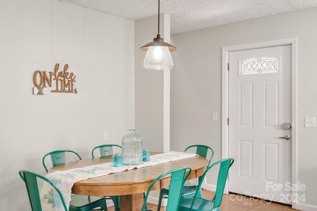 tiled dining room featuring a textured ceiling