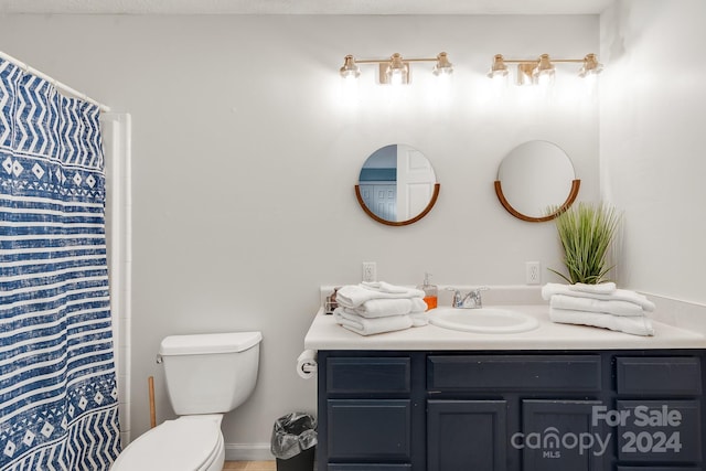 bathroom featuring a shower with shower curtain, vanity, and toilet