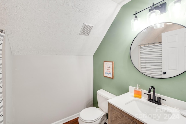 bathroom featuring hardwood / wood-style floors, vanity, lofted ceiling, toilet, and a textured ceiling