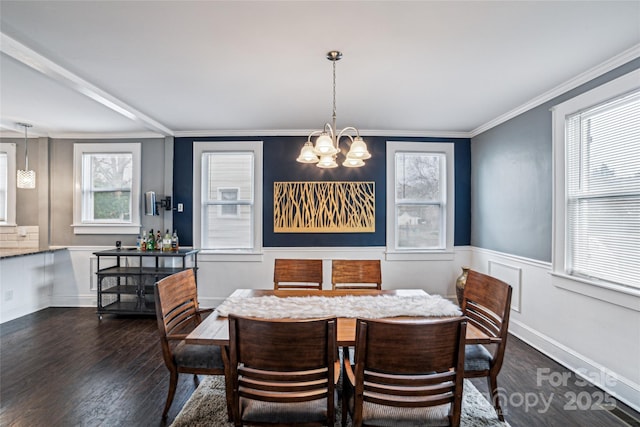 dining area with dark hardwood / wood-style floors, an inviting chandelier, and ornamental molding