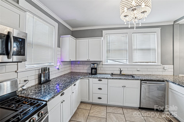 kitchen featuring white cabinets, stainless steel appliances, an inviting chandelier, and sink