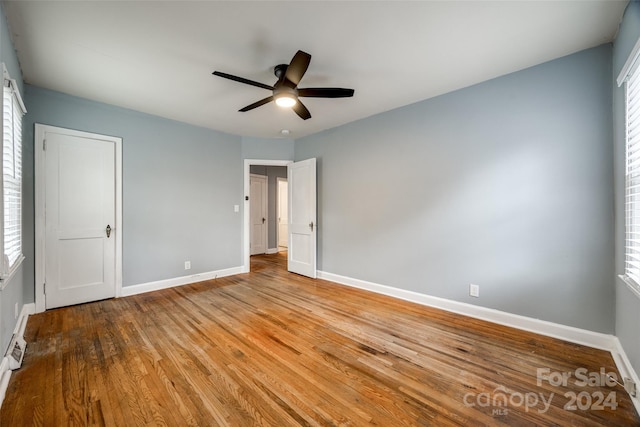 unfurnished bedroom featuring multiple windows, light hardwood / wood-style flooring, and ceiling fan