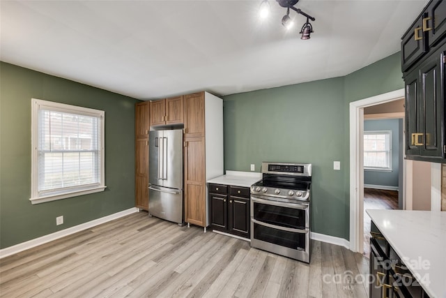 kitchen with light wood-type flooring, rail lighting, and appliances with stainless steel finishes