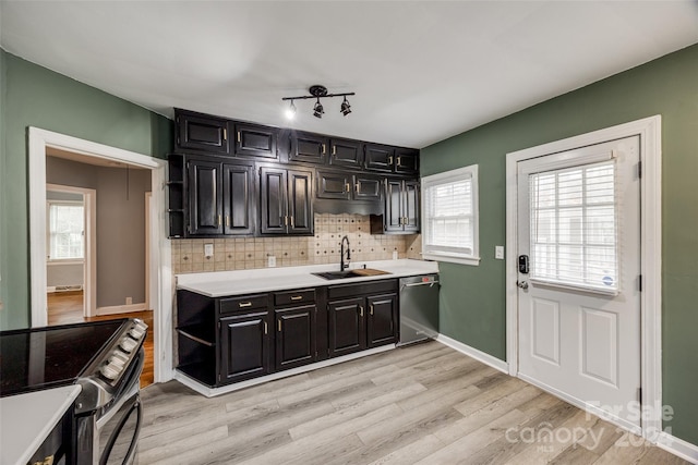 kitchen with decorative backsplash, sink, stainless steel appliances, and light hardwood / wood-style floors