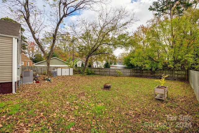 view of yard with a fire pit and a storage unit