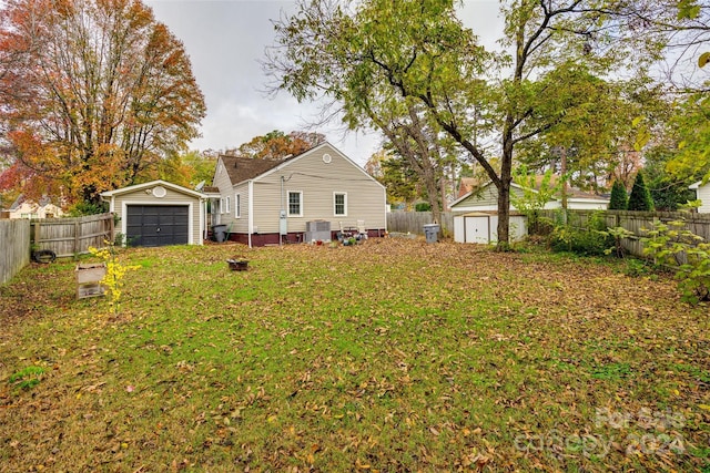 view of yard featuring an outbuilding, cooling unit, and a garage