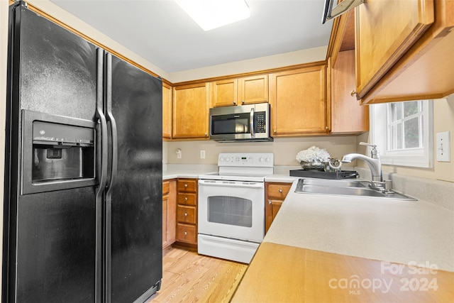 kitchen with sink, black fridge, white electric stove, and light hardwood / wood-style flooring