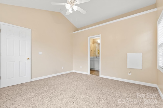 carpeted spare room with ceiling fan and vaulted ceiling