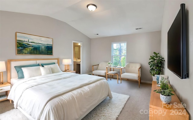 bedroom featuring carpet flooring, vaulted ceiling, and ensuite bath