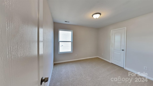 spare room featuring light colored carpet