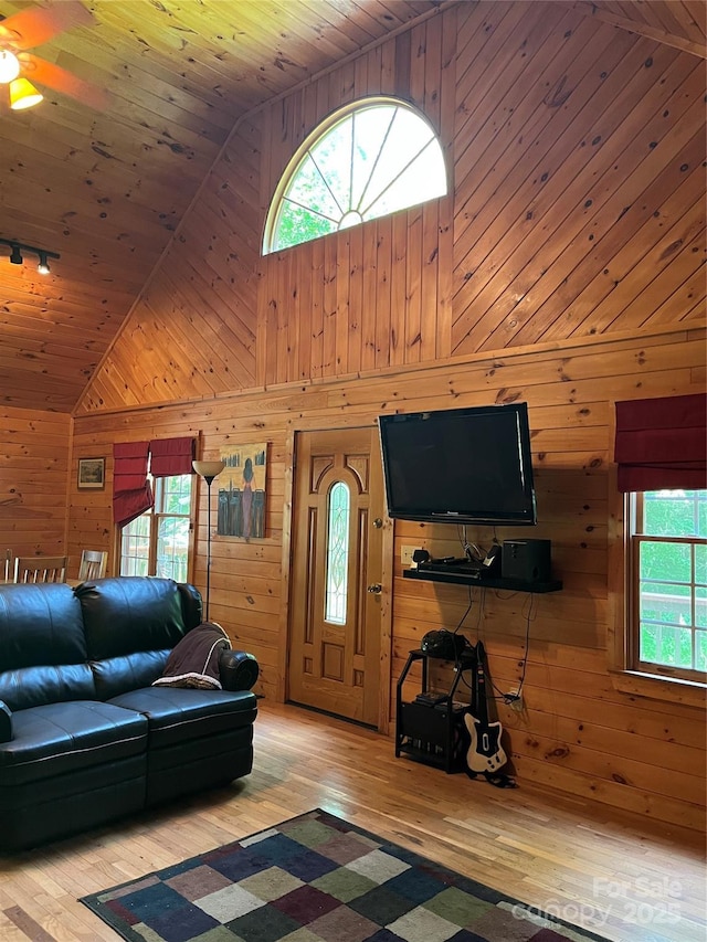 living room featuring a wealth of natural light, wooden ceiling, and wood walls