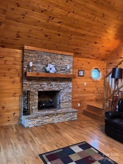 unfurnished living room featuring hardwood / wood-style flooring and wooden walls