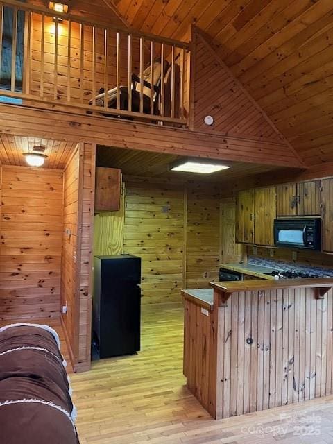 kitchen with wood walls, light hardwood / wood-style floors, and wooden ceiling