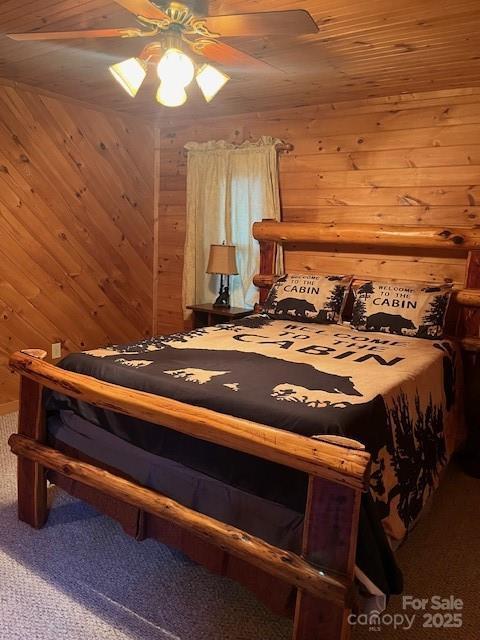 carpeted bedroom featuring wood ceiling, ceiling fan, and wood walls