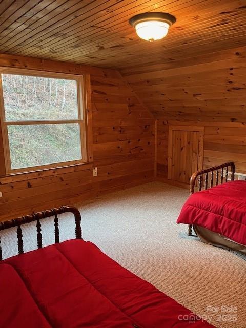 carpeted bedroom featuring wood ceiling, lofted ceiling, and wooden walls