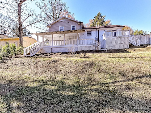 rear view of house featuring a porch, ceiling fan, and a lawn